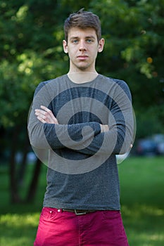 Handsome male teenager in grey shirt outdoors