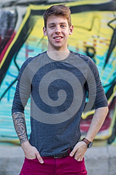 Handsome male teenager tattooed arm in grey shirt