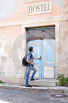 Handsome male tourist entering an old building