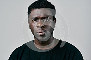 handsome man of african appearance in black t-shirt pensive look