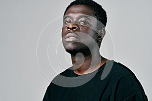 handsome man of african appearance in black t-shirt pensive look