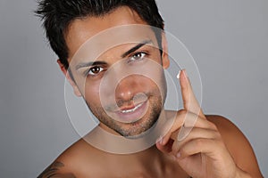 Handsome man applying facial cream