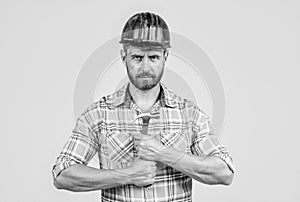 handsome man assistant in construction safety helmet and checkered shirt on building site with hammer, improvement