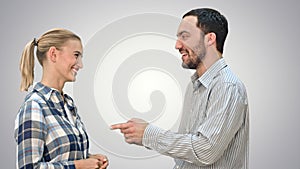 Handsome man and attractive young woman talking and smiling on white background.