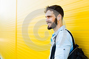 Handsome man with backpack on yellow