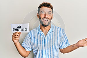 Handsome man with beard holding paper with 3d printing text celebrating achievement with happy smile and winner expression with