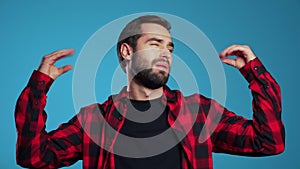 Handsome man with beard showing bla-bla-bla gesture with hands and rolling eyes