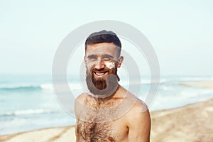 Handsome Man with beard, In Sunglasses Sunbathing With Sunscreen Lotion Body In Summer. Male Fitness Model Tanning Using Solar Blo