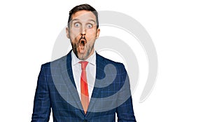 Handsome man with beard wearing business suit and tie afraid and shocked with surprise expression, fear and excited face