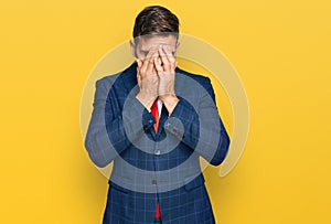 Handsome man with beard wearing business suit and tie with sad expression covering face with hands while crying