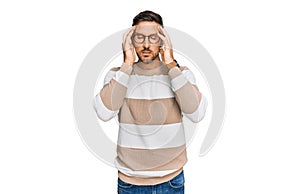 Handsome man with beard wearing casual clothes and glasses with hand on head, headache because stress