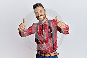 Handsome man with beard wearing hipster elegant look approving doing positive gesture with hand, thumbs up smiling and happy for