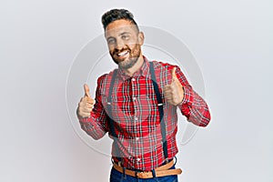 Handsome man with beard wearing hipster elegant look success sign doing positive gesture with hand, thumbs up smiling and happy