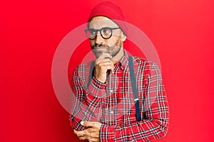 Handsome man with beard wearing hipster elegant look thinking concentrated about doubt with finger on chin and looking up