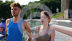 Handsome man and beautiful woman working out on street running together on the bridge with nice view. Close up of