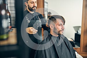 Kind bearded male person sitting in semi position