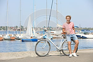 Handsome man with bicycle at pier