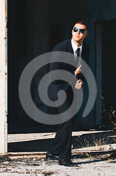 Handsome man in black suit and sunglasses. Secret agent, mafia, bodyguard concept