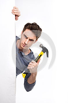 Handsome man with blank card holding hammer isolated on white