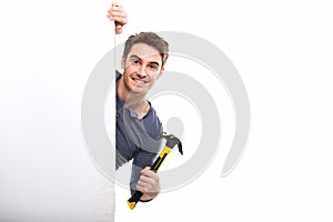 Handsome man with blank card holding hammer isolated on white