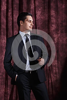 Handsome man in a business suit on a dark background