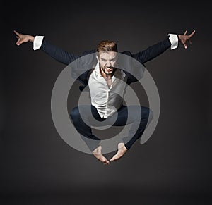 Handsome Man in Business Suit Jumping in Air, Full Length Young Ballet Dancer over Black Background