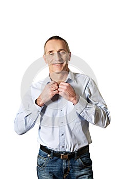 Handsome man buttoning his shirt