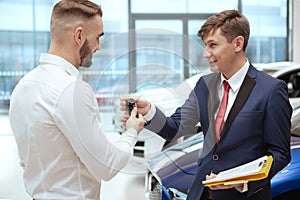 Handsome man buying new car at the dealership