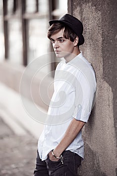 Handsome man casually leaning against the wall