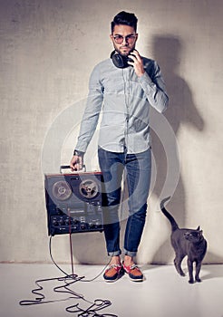 Handsome man and cat listening to music on a magnetophone