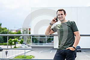 Handsome man cell phone call smile outdoor city street. Young attractive businessman casual blue shirt talking on the phone