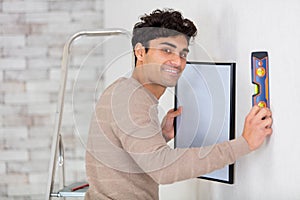 handsome man checks level on wall