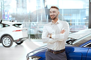 Handsome man choosing new automobile at the dealership