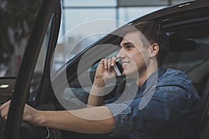 Handsome man choosing new automobile to buy