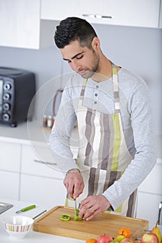 handsome man chopping vegetables at home