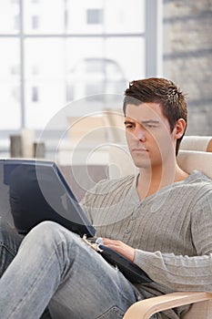 Handsome man concentrating on laptop screen photo