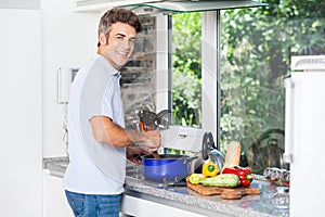 Handsome man cooking at home kitchen smile