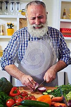 Handsome man cutting onion on chopping board