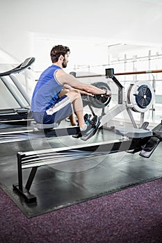 Handsome man doing exercise on drawing machine