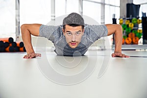 Handsome man doing push-ups in gym