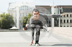 Handsome man doing yoga asana in urban area