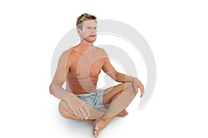 Handsome man doing yoga and sitting in lotus position