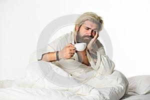 Handsome man drink coffee. Mature bearded man in bed. Body has been deprived of essential component for good health and