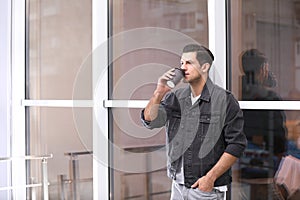 Handsome man drinking coffee near window