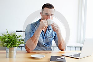 Handsome man drinking coffee in the office