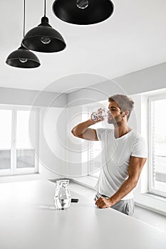 Handsome Man Drinking Glass Of Fresh Water Indoors In Morning