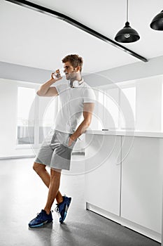 Handsome Man Drinking Glass Of Fresh Water Indoors In Morning