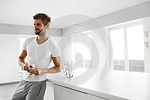 Handsome Man Drinking Glass Of Fresh Water Indoors In Morning