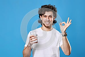 handsome man with drinking glass of water showing Ok