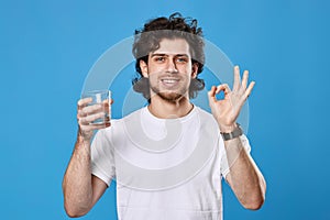 handsome man with drinking glass of water showing Ok